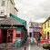 Quaint shops line a patio with tables, chairs and benches